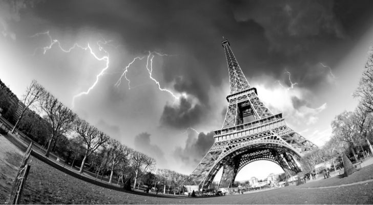 A dramatic photo of the Eiffel Tower with lightning in the sky
