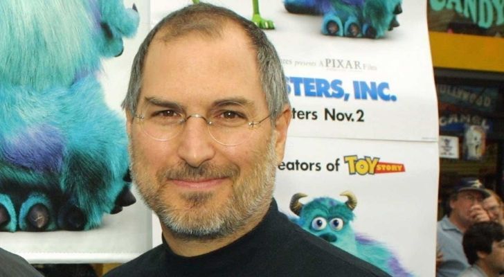 Steve Jobs with a Pixar poster behind him